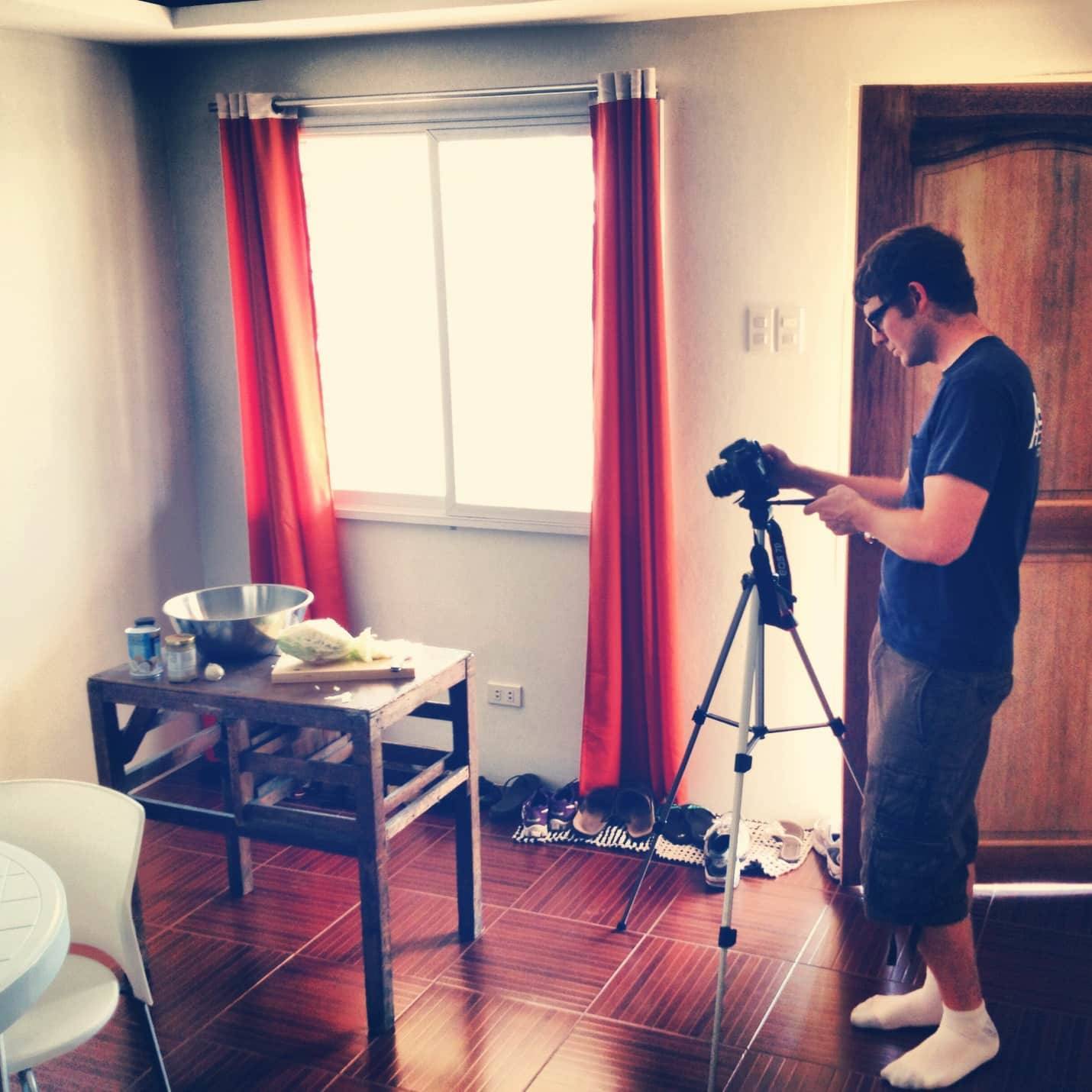 Man taking photos with a camera and a tripod.