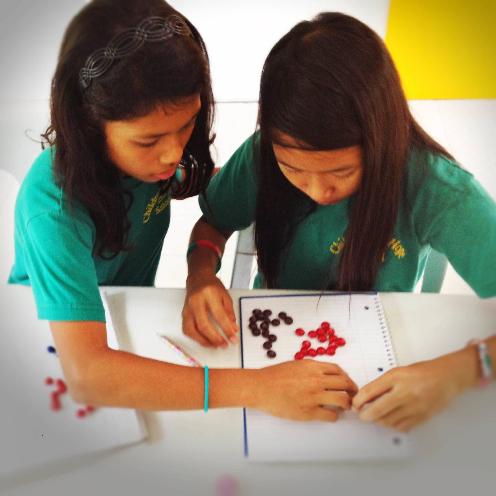 Two young girls working with candy.