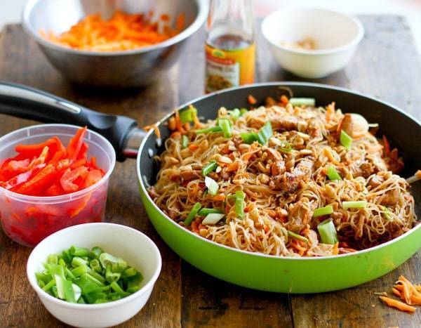 Hoisin pork with rice noodles in a green skillet.