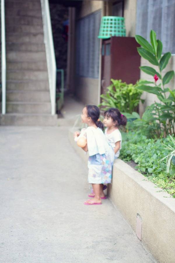 Little girls on a sidewalk.