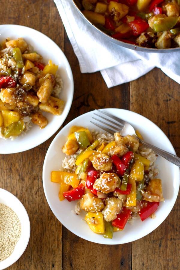 Sweet and sour fish on white plates with a fork.
