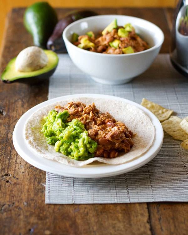 Mexican chicken and pinto beans on a tortilla.