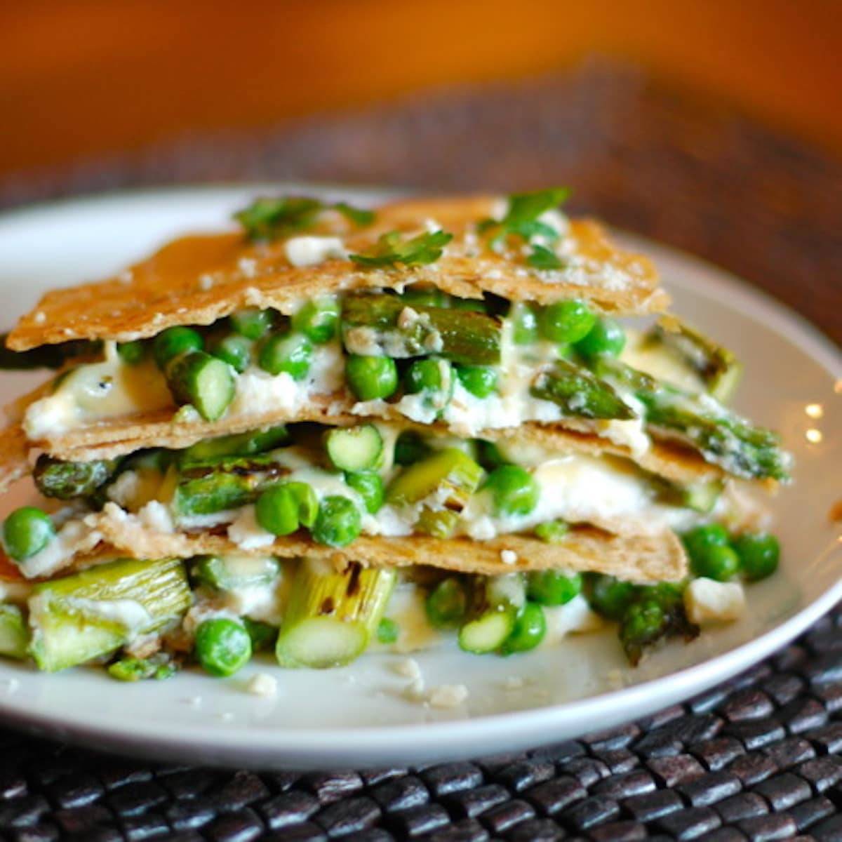 Asparagus quesadilla lasagna stacked on a white plate.