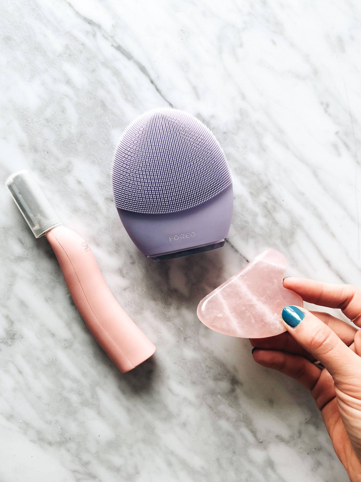 White hand holding gua sha stone