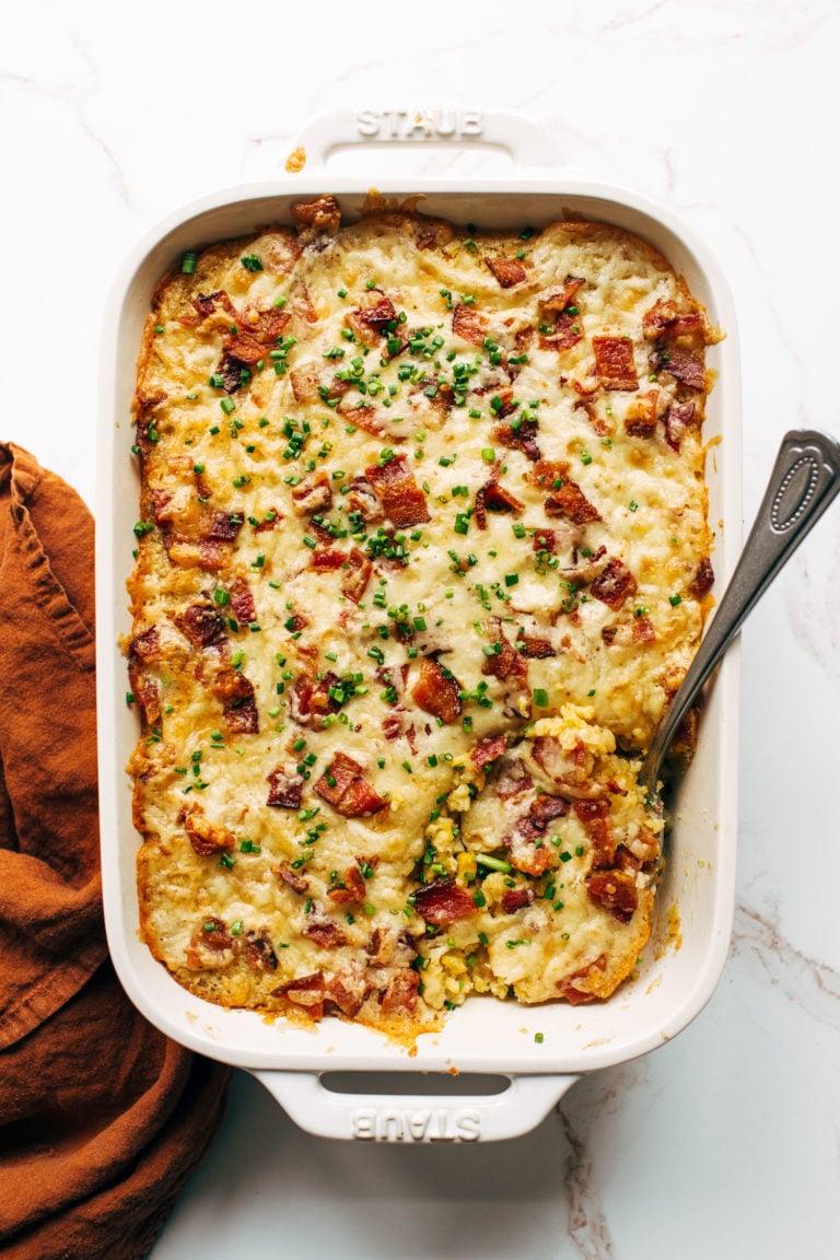 Corn casserole in a casserole dish with a serving spoon.