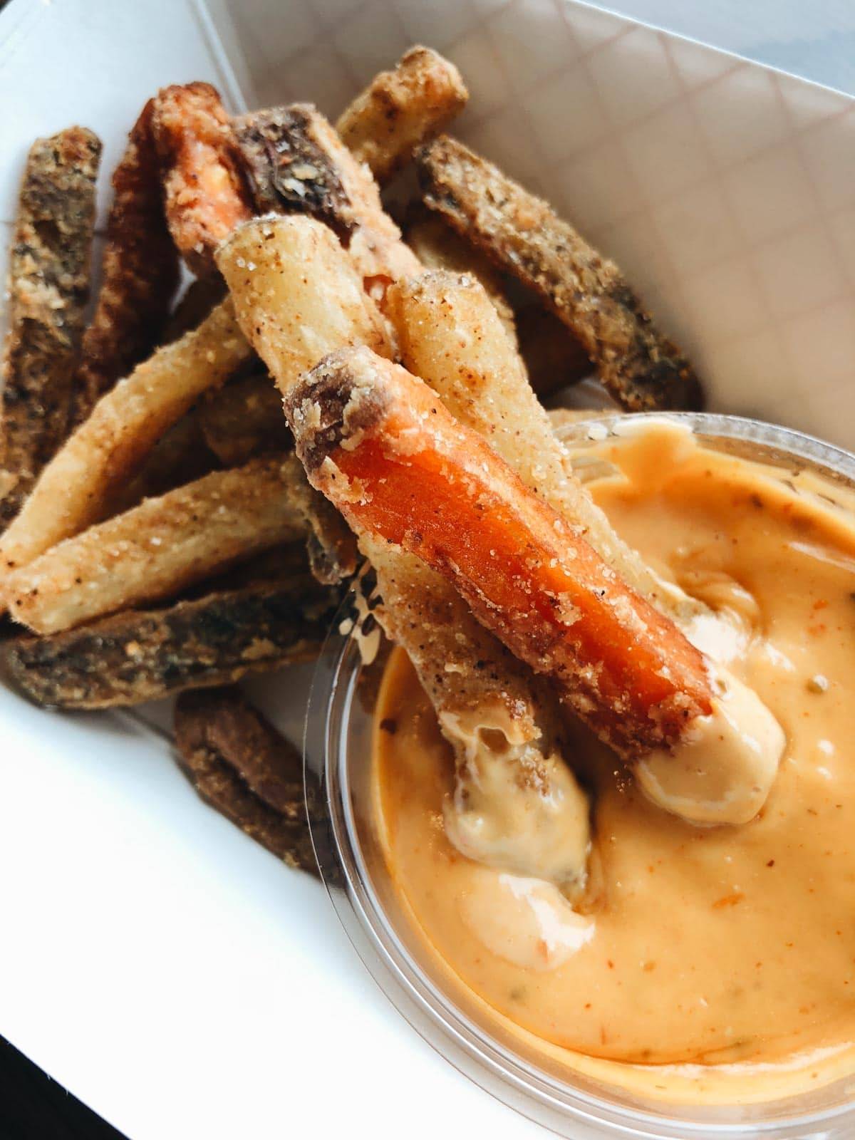 Hot Indian Frites with a dipping sauce in a bowl.