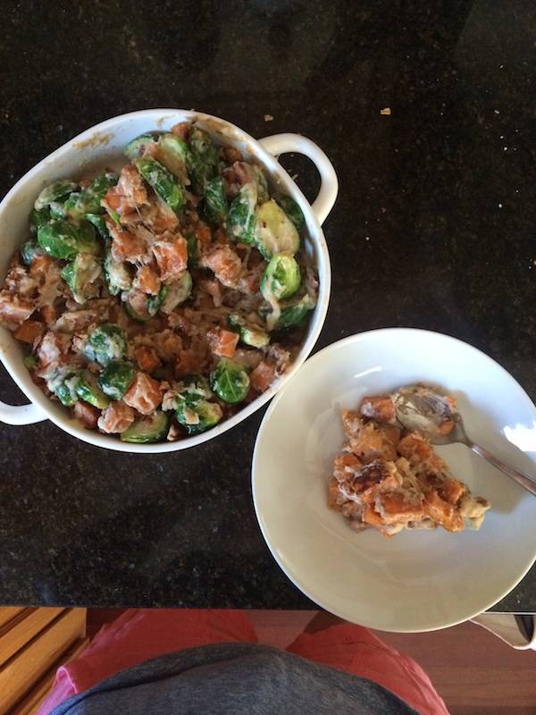 Sweet potatoes and brussels sprouts and a white plate.