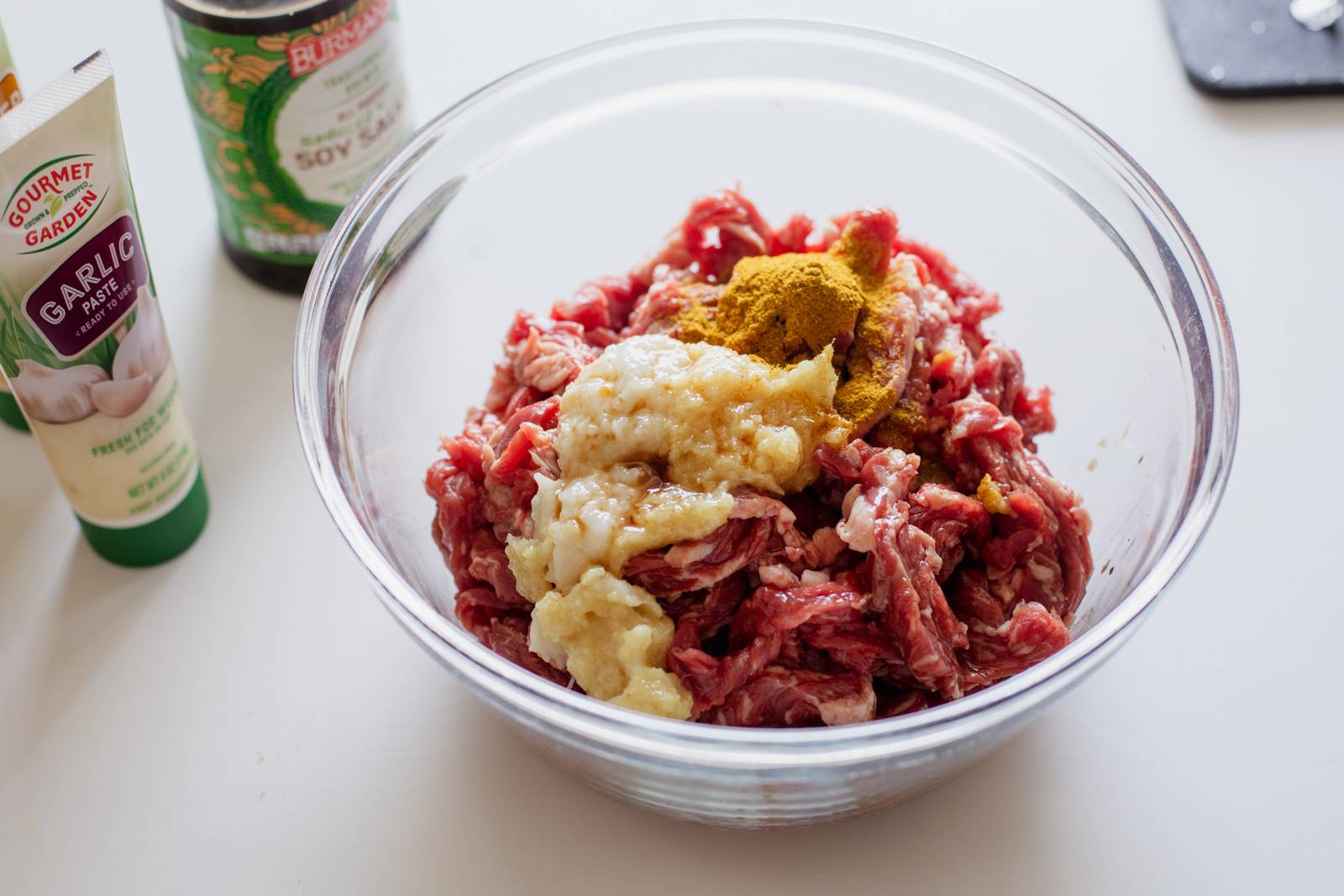 Mixing steak in a bowl with marinade.