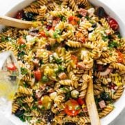 Pasta salad in bowl with spoons.