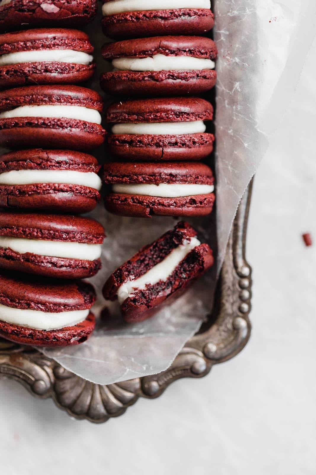 A half eaten macaron lays next to other cookies.