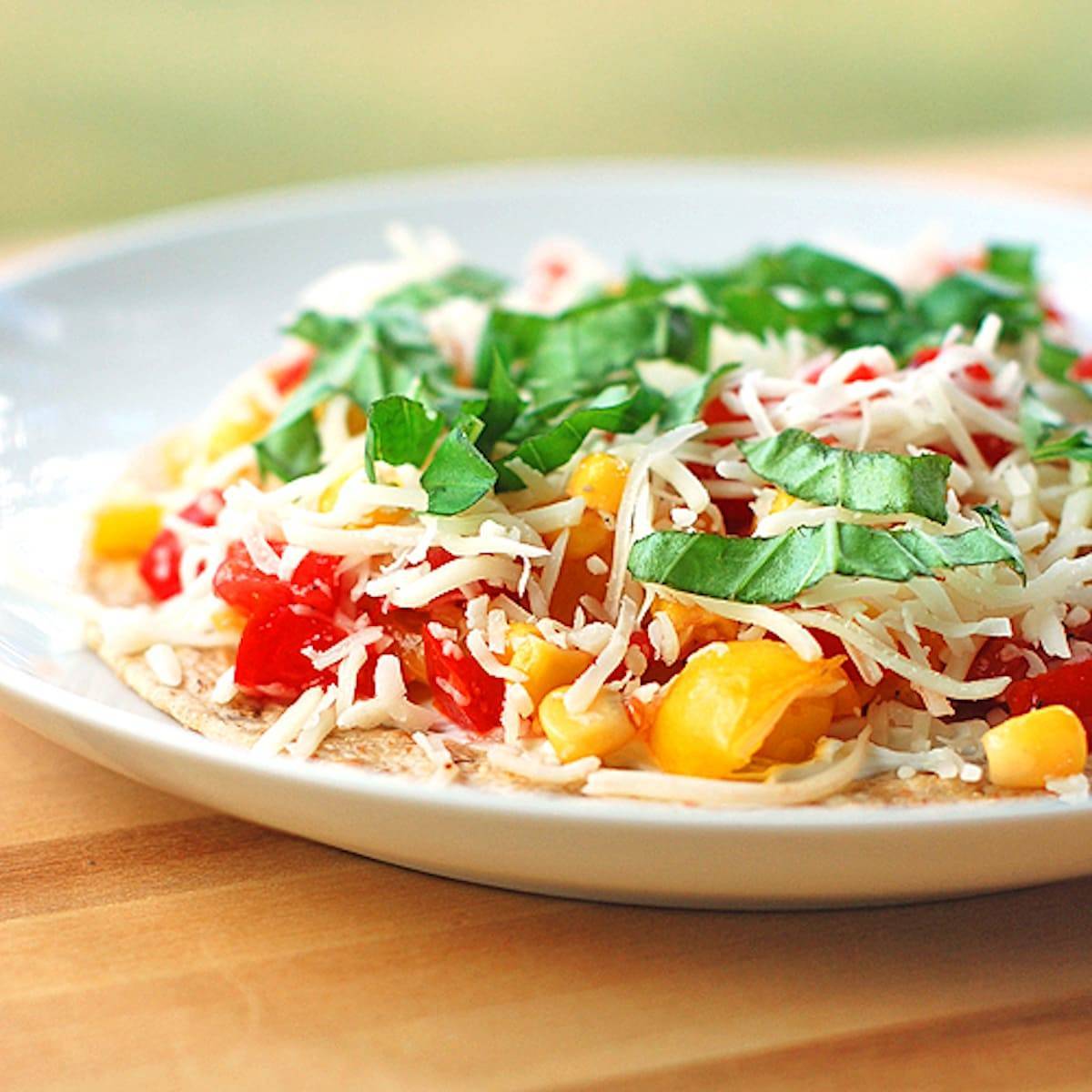 Mozzarella, Basil, and Corn Quesadilla on a white plate.