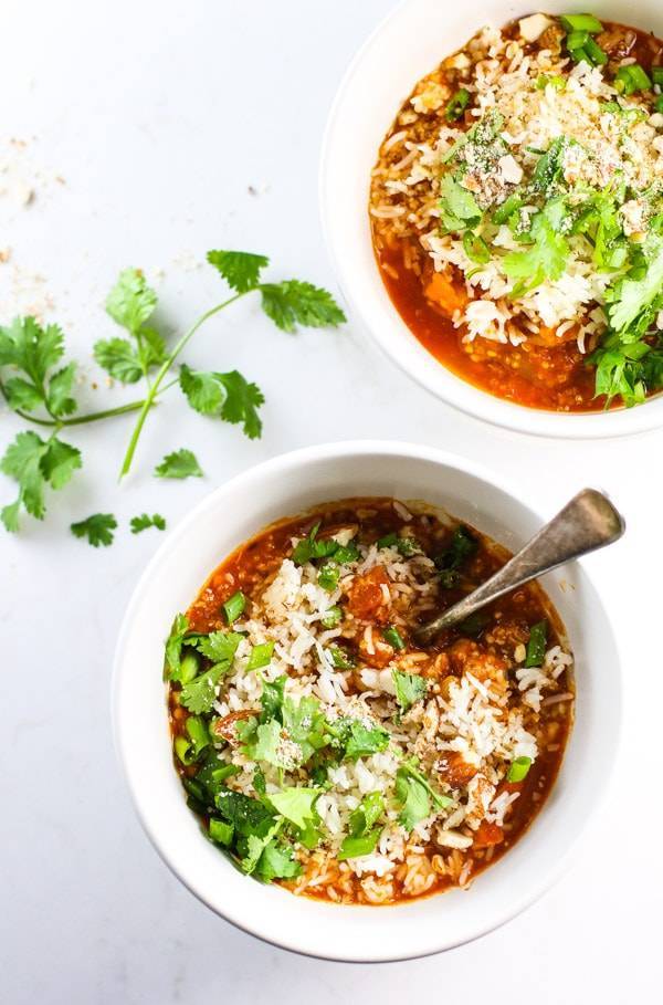Two Quinoa Chicken Curry Bowls with herb toppings.