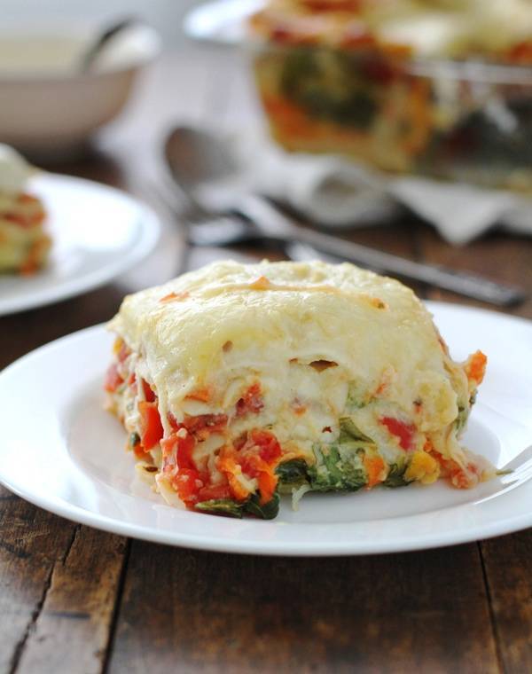 Veggie Alfredo lasagna on a white plate.